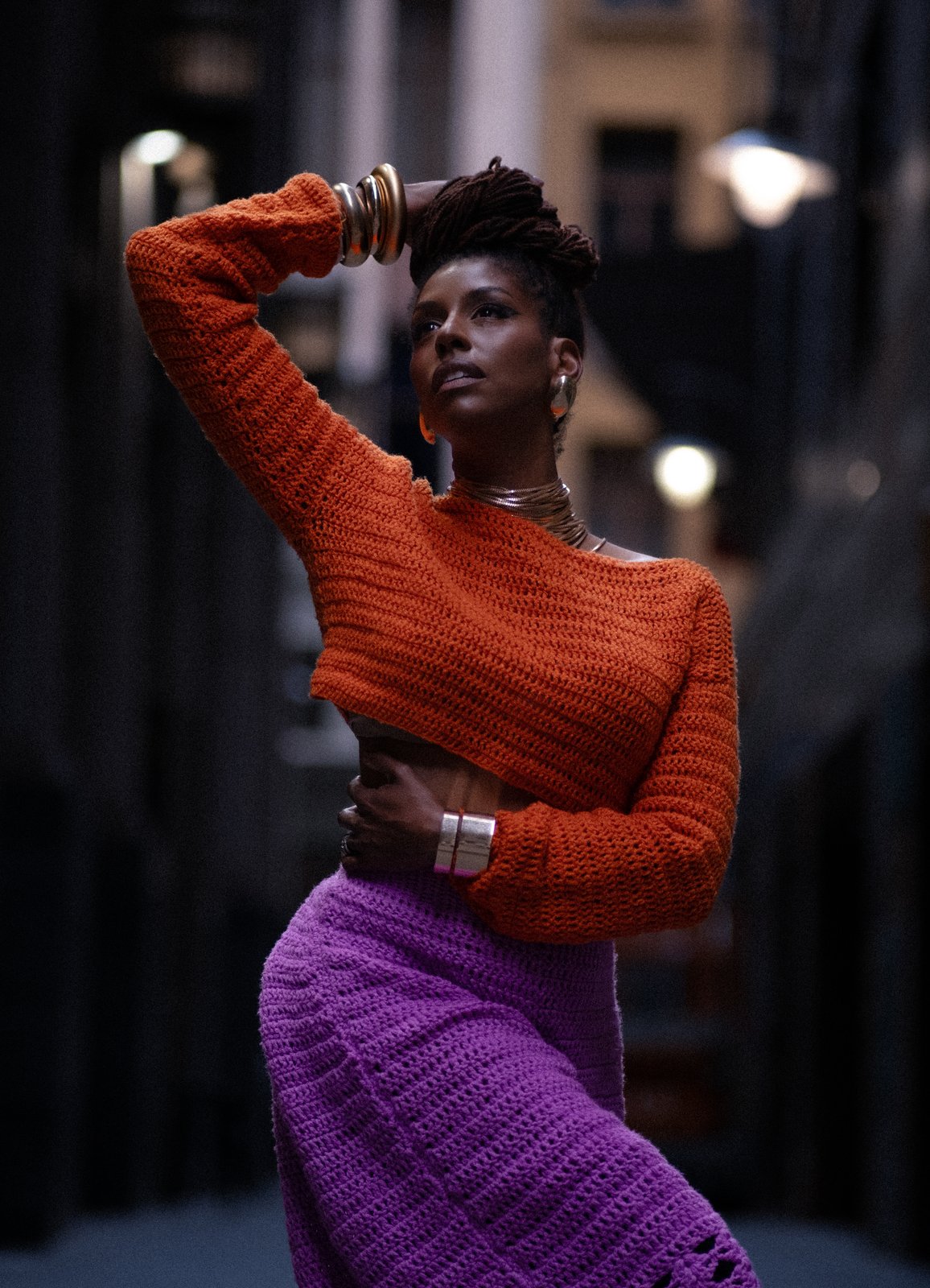 ÉKO Melbourne launch campaign — editorial portrait in a Melbourne laneway, orange knit and gold cuffs